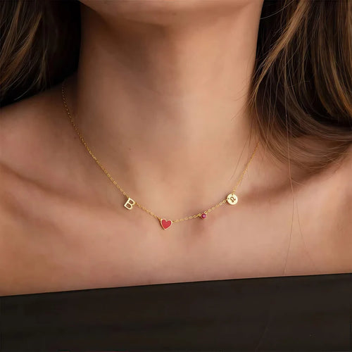 Modella con la collana in oro, cuore rosso e pietra del mese